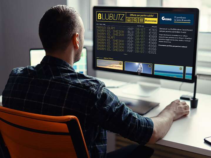 Uomo di spalle che osserva un computer con la home page del sito BluBlitz